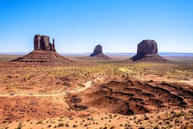 An der Grenze zwischen Utah und Arizona ragen rote Sandsteintürme und Tafelberge bis zu 300 Meter über eine flache Wüste – Monument Valley